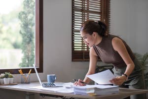 Business woman using calculator for do math finance on wooden desk in office and business.