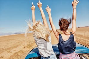 Two travelers enjoy a road trip.